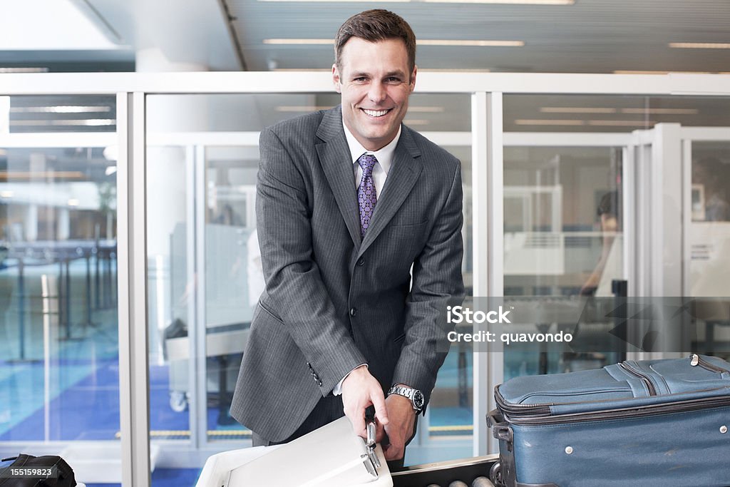 Beautiful Businessman Smiling at Airport Security, Copy Space Handsome young Caucasian man smiling at the airport security checkpoint. Copy space on either side. CLICK FOR SIMILAR IMAGES AND LIGHTBOX WITH BUSINESS PEOPLE.  Airport Stock Photo