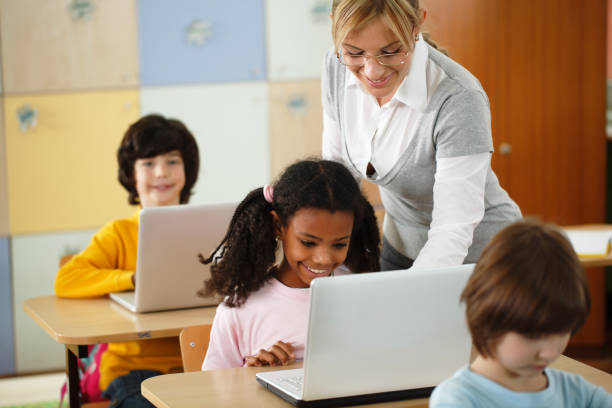 istock School children using laptops with teacher in the classroom 155159930