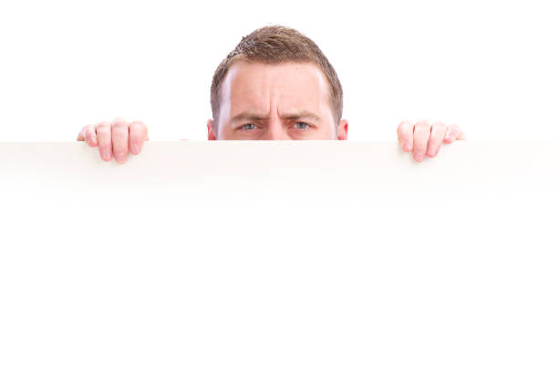 istock young male peeking over sign 155159978