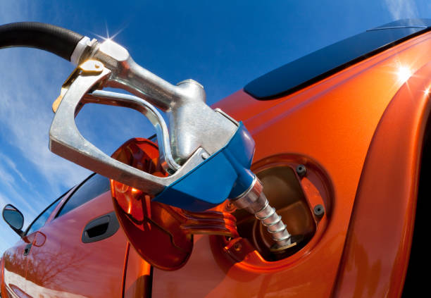 Pumping Gas Into Gas-Guzzler on a Sunny Day.  This image is shot with a super-wide angle lens for a uniquely dynamic and fun perspective.