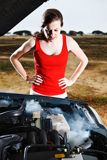 istock Pretty brunette looking into smoking car engine frustrated and worried 155160167
