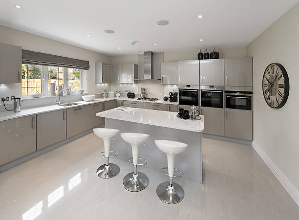 light grey kitchen a spacious kitchen in a luxury new house prepared by an interior designer. Three kitchen stools sit in front of a large island. All cupboard fronts are silver grey. breakfast room photos stock pictures, royalty-free photos & images