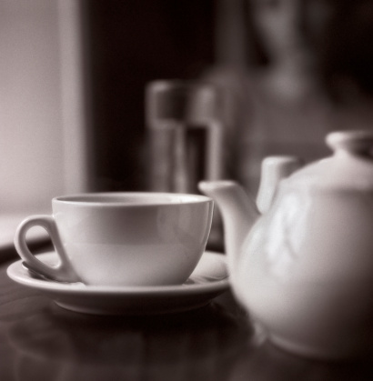 Only the tea cup is (partially) in focus. Film grain visible (scan from a 120 Delta 3200). Toned.