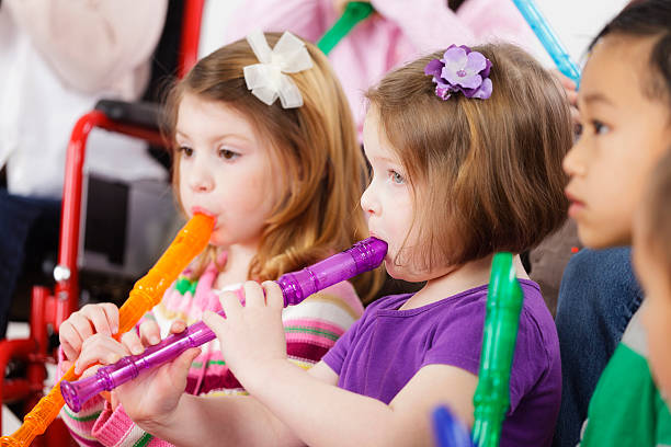 A group of preschool children in a music class.