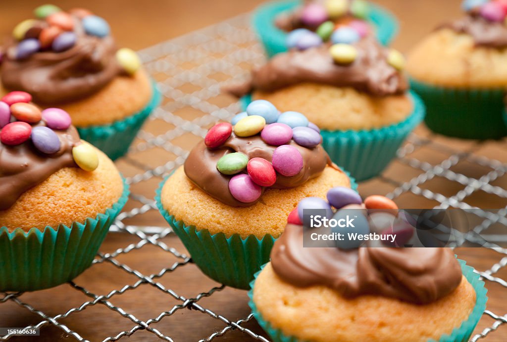 Vanilla cupcakes with blue lining Cup cakes freshly made topped with chocolate and candy Baking Stock Photo