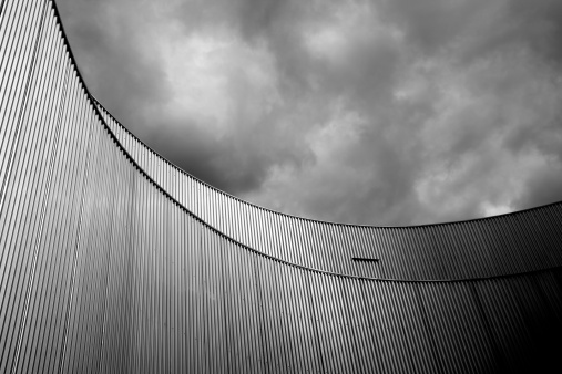 Building with metal covering against stormy sky\u2028http://www.massimomerlini.it/is/black&white.jpg\u2028http://www.massimomerlini.it/is/abstractarchitecture.jpg