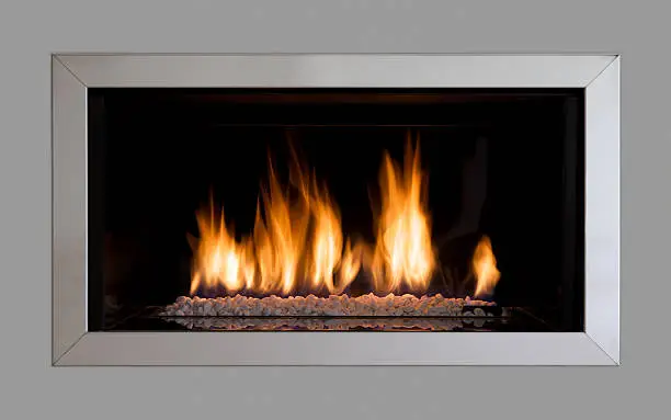 a modern gas fire with a stainless steel surround fitted in a grey coloured wall in a luxury new home. A clipping path has been applied afterwards to enable a different background to be applied if desired. A slower shutter speed has been applied to soften the flames.