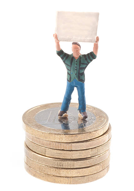 männchen mit plakat auf euromünzen - figurine small plastic businessman стоковые фото и изображения