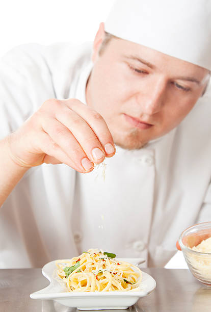 istock Young chef putting finishing touches on a pasta dish 155161432