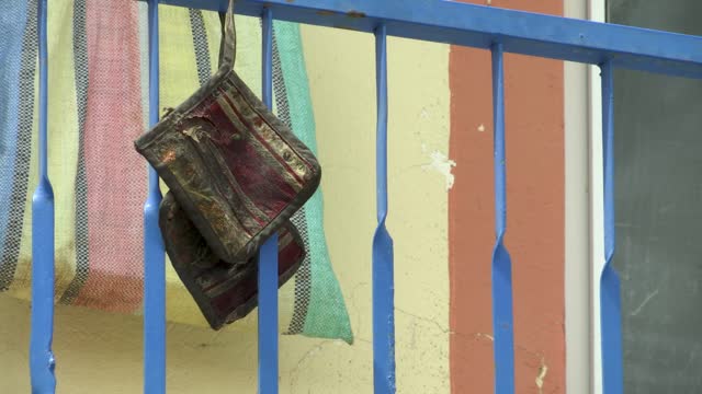 Vintage Saddlebag-Like Bag Hanging on the Blue Iron Balcony of a Village House