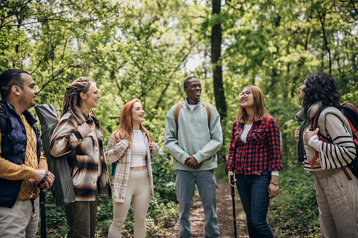 Multi-racial group of friends, male and female hikers standing together in nature.