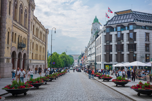 Oslo, Norway, June 20, 2023: People walk along Karl Johans gate, the main street Oslo that has many tourist attractions such as Royal Palace, Central Station and Stortinget, restaurants, and shops.