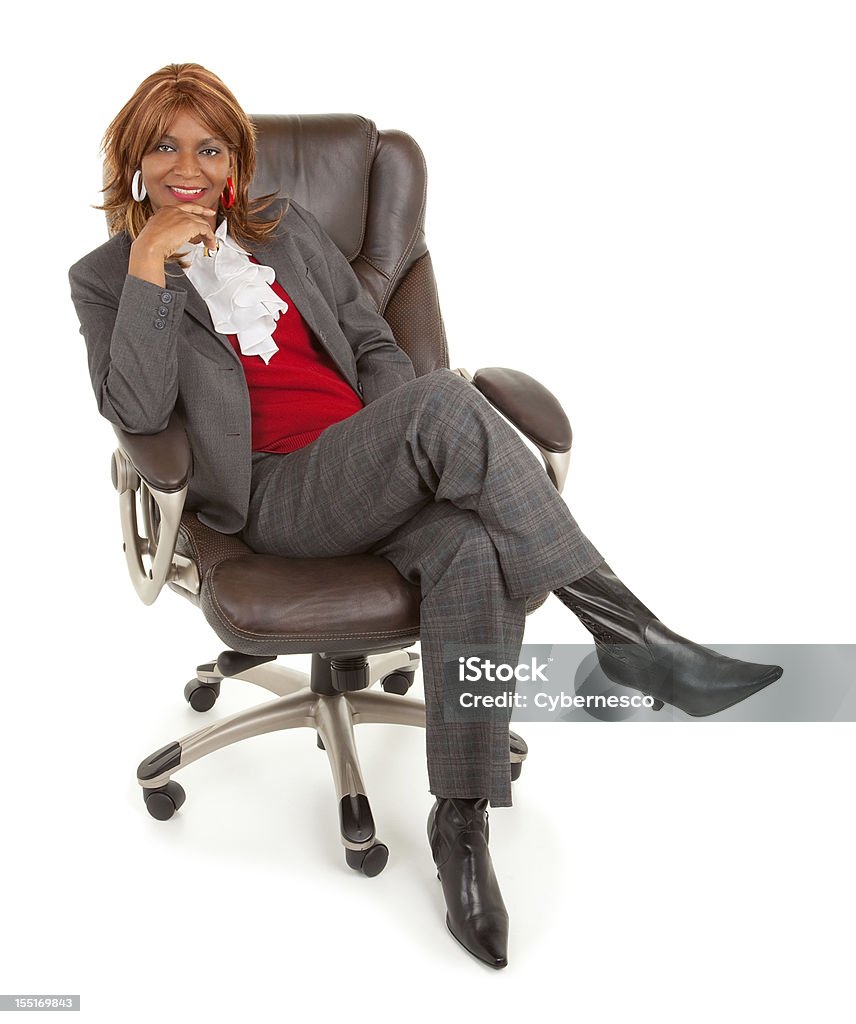 African American Businesswoman Sitting on a Leather Chair A smiling African American businesswoman is sitting on a leather chair. Chair Stock Photo