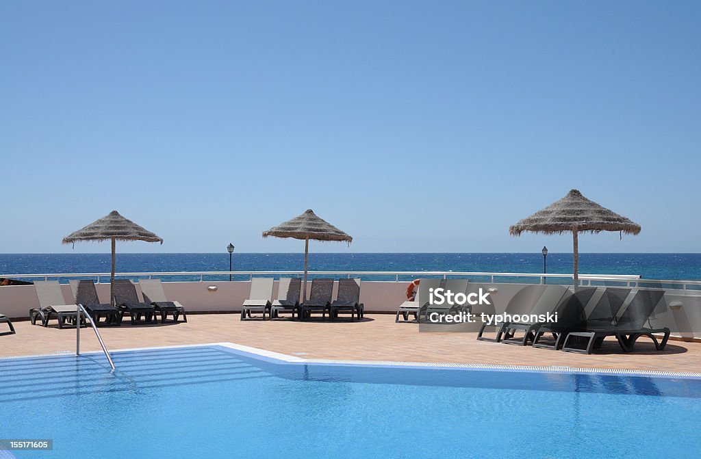 Piscine dans le complexe tropical - Photo de Ombrelle libre de droits