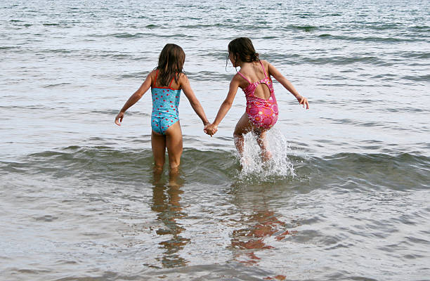 Twin sisters jump waves in Lake Michigan at Whitefish Dunes State park in Door County. The park was established in 1967 to protect the sand dune environment in Northern Wisconsin.