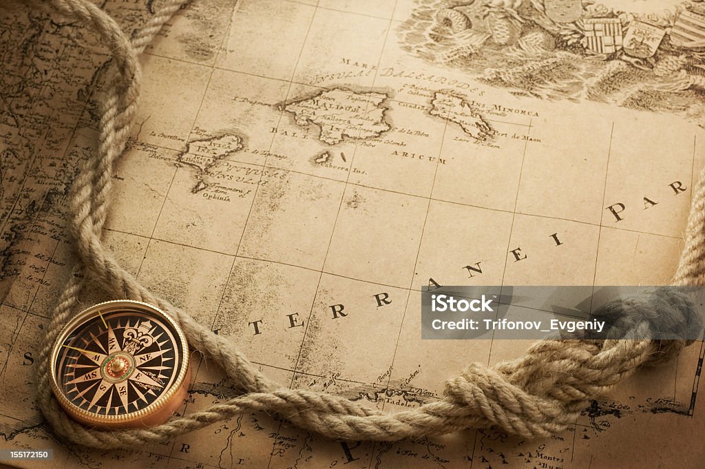 Vintage style image in sepia of an old map, rope and compass compass Navigational Compass Stock Photo