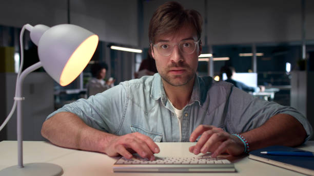 istock Casual entrepreneur sit at desk in modern office late at night 1551749486
