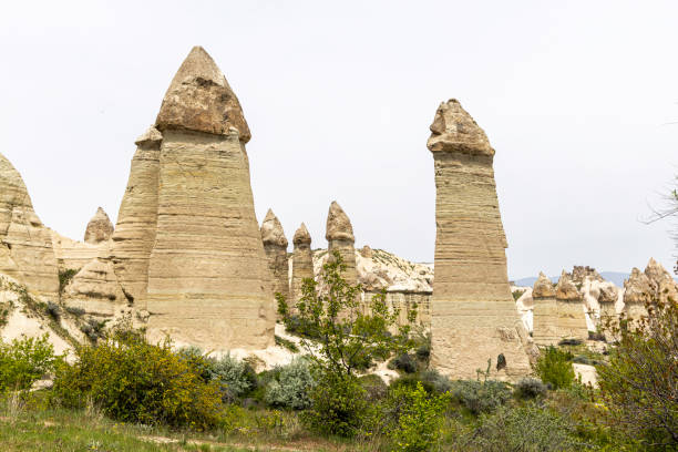 formação rochosa chamada chaminés de fadas em love valley, goreme, capadócia, turquia. - goreme rural scene sandstone color image - fotografias e filmes do acervo