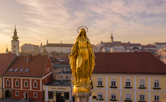 ZAGREB, CROATIA - DECEMBER 31, 2019: Golden Statue, Monument in front of Zagreb Cathedral in Croatia. It is on the Kaptol, is a Roman Catholic institution and the tallest building in Croatia. Sacral building in Gothic style