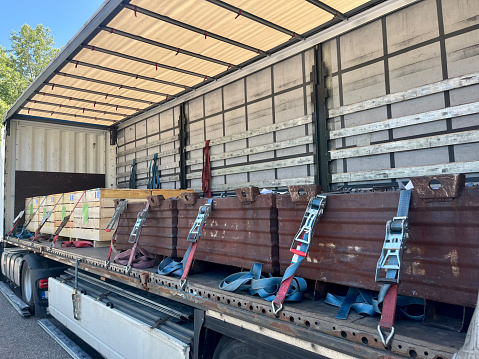 Cargo transportation of screws in wooden and metal boxes in a semi-trailer truck. Side loading of bolts.