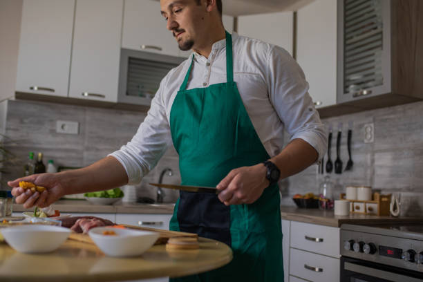 istock Young handsome man is preparing food in his kitchen. Cooking with love. 1551845454