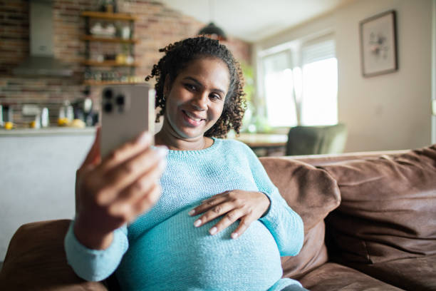 istock Young pregnant woman using a smart phone at home 1551878755