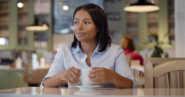 istock Young woman drinking coffee in restaurant and relaxing 1551881812