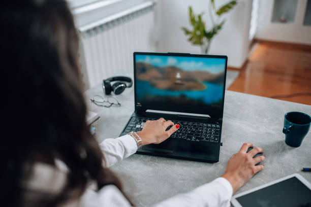 istock Mid-adult professional balances work and personal life, leveraging her laptop for efficient task management in her home office 1551909423