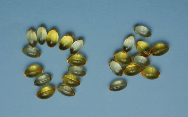 les capsules sont disposées en forme de soleil sur fond bleu. - fatty acid photos et images de collection