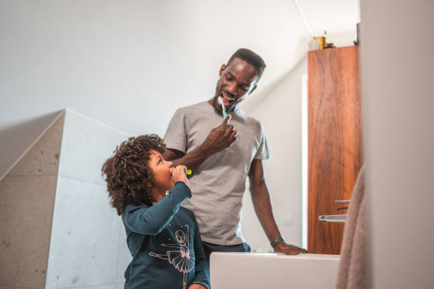 istock Smiling Black Gay Father Teaching Dental Hygiene to His Son 1551948617