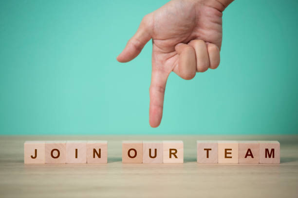 istock Job recruiting advertisement. represented by 'JOIN OUR TEAM' texts on the block. and hand point down to wood block 1552169510