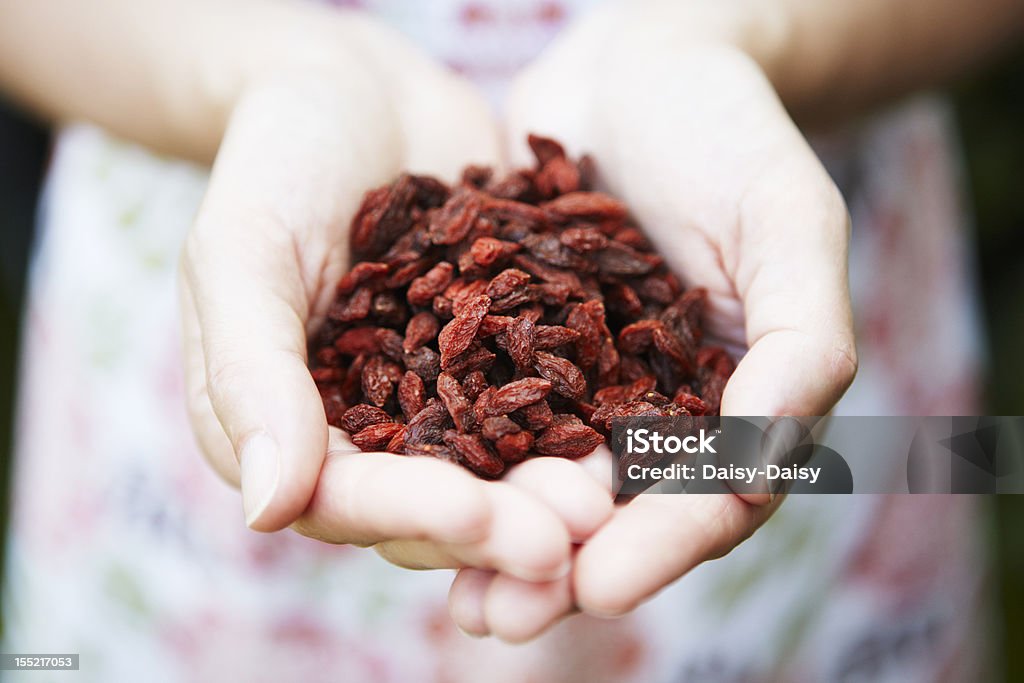 Donna con una manciata di Goji Frutti di bosco - Foto stock royalty-free di Adulto