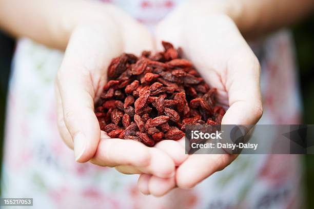 Mulher Segurando A Mão Cheia De Bagas Goji - Fotografias de stock e mais imagens de Adulto - Adulto, Adulto maduro, Alimentação Saudável