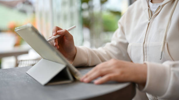 istock An Asian female freelancer using her digital tablet while siting in a coffee shop 1552171757