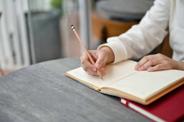 istock A woman writing something on her notebook while sitting at a table in the coffee shop. 1552171942