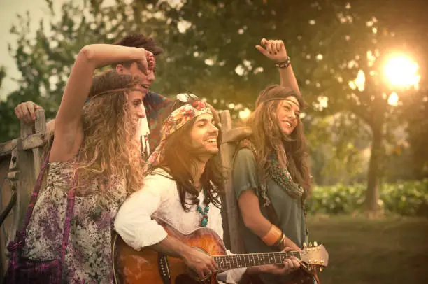 Photo of Hippies Dancing and Playing Guitar . 1970s style.
