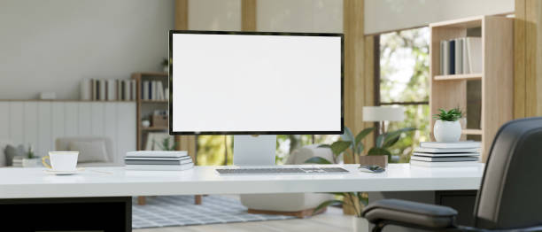 istock A modern computer mockup with accessories on a table in a modern cozy living room. 1552175596
