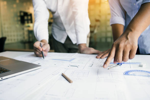 Structural engineering designers are working on the blueprints and analyzing them together. stock photo