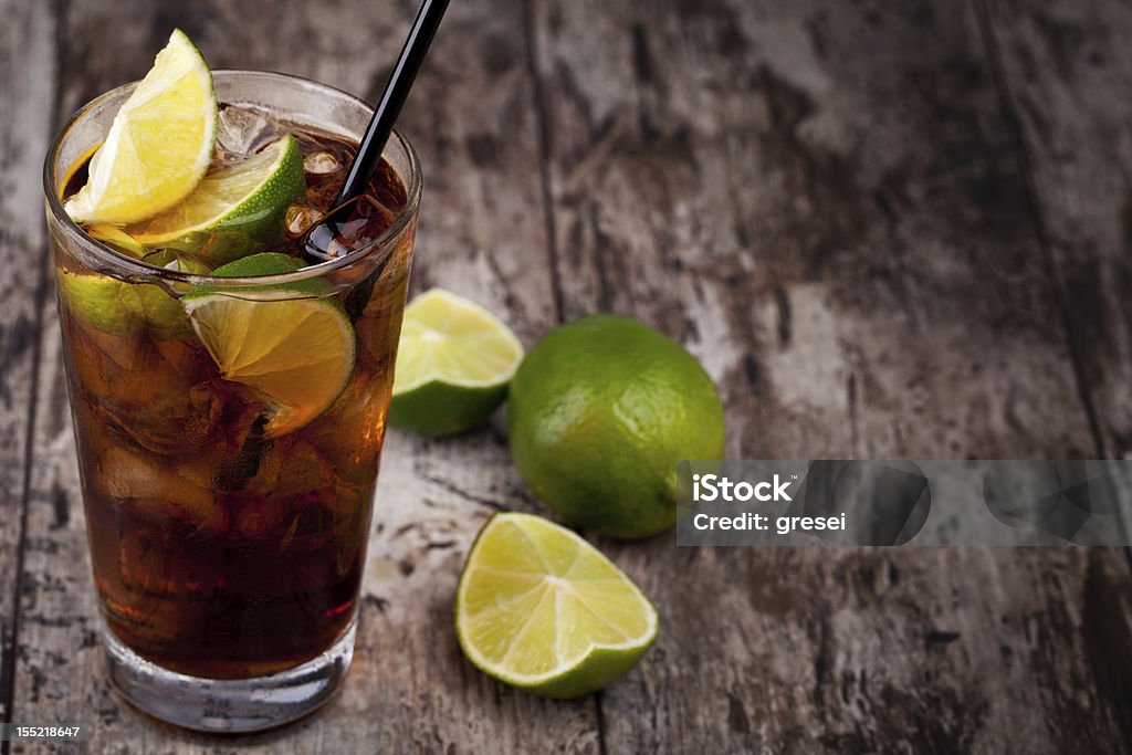 Cuba Libre drink placed on rustic table Cuba Libre Drink with lime on a wooden table Cuba Libre Stock Photo