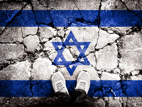Double exposure of the flag of Israel with cracks in the gravel. A symbol of disintegration or division is depicted. Steps toward collapse. Useful for basemaps or report descriptions