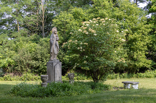 Mankato, Minnesota, USA - June 17, 2023: This image shows the sculpture of Our Lady of Good Counsel, adorning the hillside edge on the campus of Our Lady of Good Counsel, established in 1912 by the School Sisters of Notre Dame.