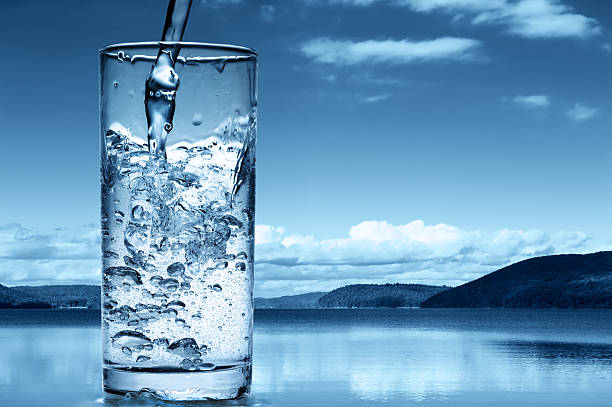 Pouring water into a glass stock photo