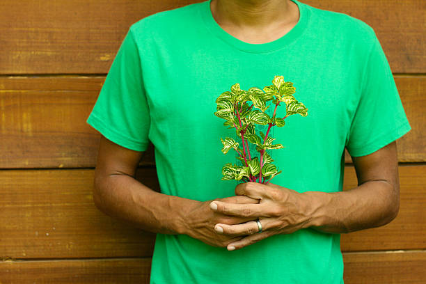 Man in green with flowers wooden wall background stock photo