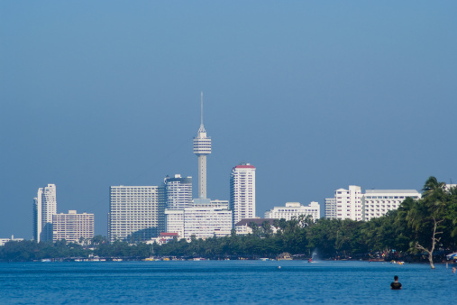 Jomtien Beach in Pattaya, Thailand with high-rise hotels and apartment buildings in the background.  