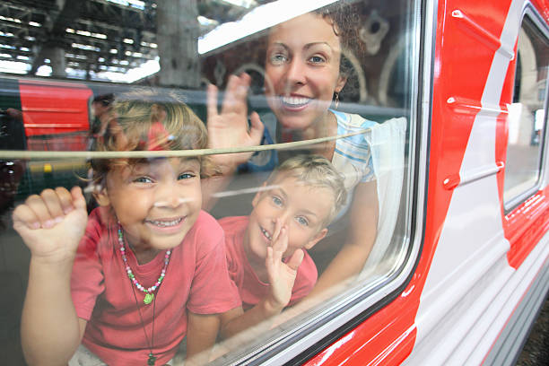 Mother and children look from train window stock photo