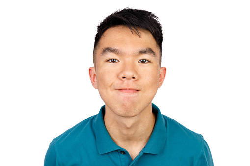 A male teenage Asian student is leaning forward, looking at the camera while smiling. He is wearing a blue golf shirt. The background is white cutout isolated.
