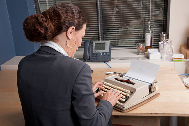 Businesswoman at typewriter stock photo
