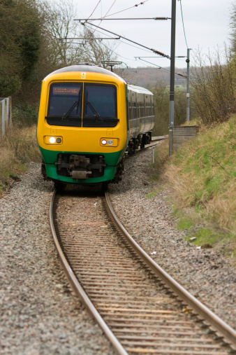 A suburban commuter train curves towards a station.