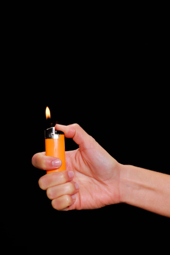Female hand holding a lighter.