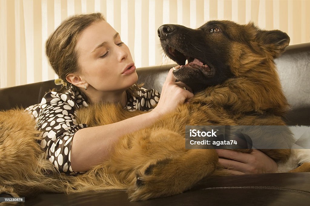 若い女性は彼女の犬と花輪のソファー - ジャーマンシェパードのロイヤリティフリーストックフォト